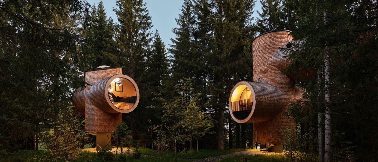 In Baumhäusern mit origineller Architektur übernachten Gäste nahe des Wirtshauses Steirereck am Pogusch in der Steiermark.